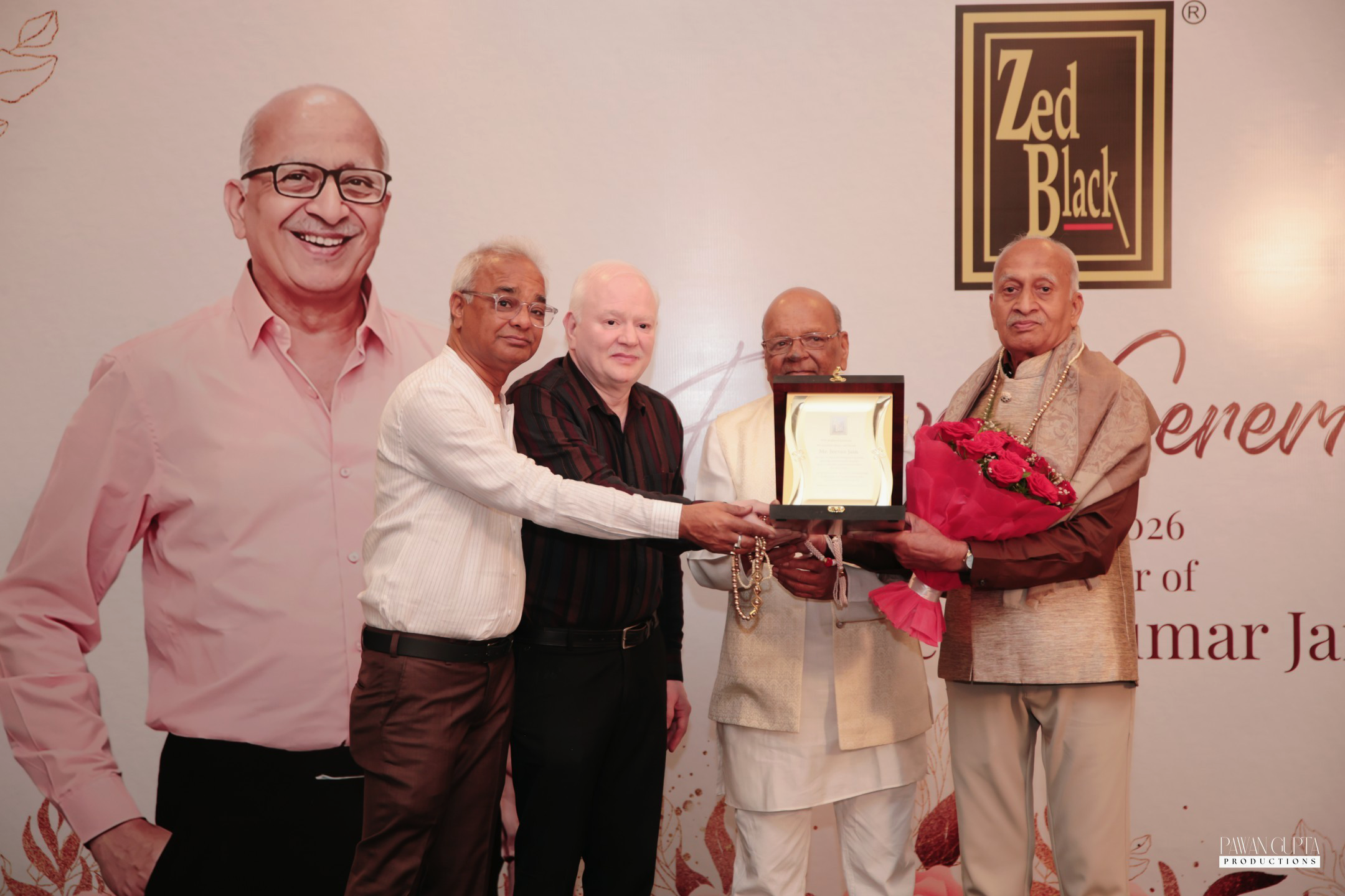 Zed Black felicitation ceremony honoring Mr. Jeevan Kumar Jain, featuring dignitaries presenting him with an award and bouquet in recognition of his 35 years of dedication.
